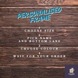Puede incluir: Fondo de madera con el texto "PERSONALISED FRAME" en azul y blanco. Debajo, pasos numerados gu&iacute;an al cliente: Elegir tama&ntilde;o, elegir nombre, elegir color y esperar el pedido. El logotipo de Frameifly est&aacute; en la parte inferior derecha.