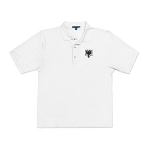 Könnte beinhalten: Weißes Poloshirt mit kurzen Ärmeln und einem schwarzen gestickten Adler auf der linken Brust.
