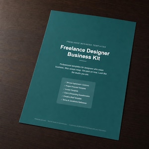 May include: A teal business kit titled "Freelance Designer Business Kit" with white text. The kit includes templates for designers, such as a service agreement, project proposal, and invoice template. The kit is on a dark brown wooden surface.