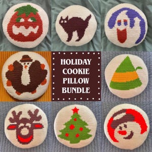 May include: A collection of round, cream-colored crochet pillows with holiday-themed designs. The designs include a pumpkin, black cat, ghost, turkey, elf hat, reindeer, Christmas tree, and snowman. The text "HOLIDAY COOKIE PILLOW BUNDLE" is also visible.