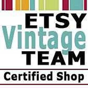 May include: A square logo featuring the text ETSY Vintage TEAM in black and light blue, with the words Certified Shop in black below a horizontal line. The top border consists of vertical stripes in maroon, yellow, light blue, and dark pink.