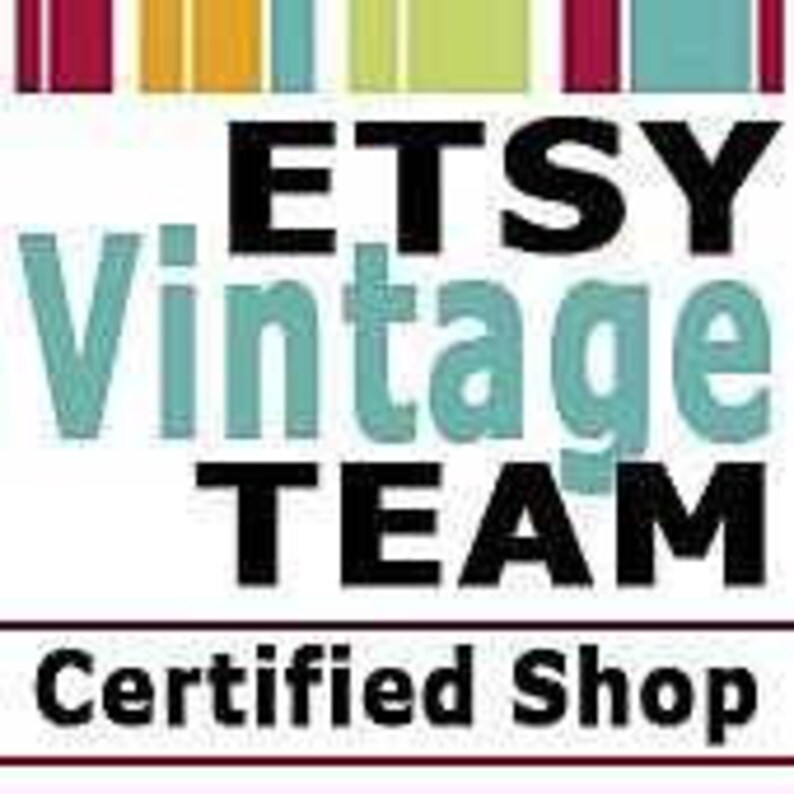 May include: A square logo featuring the text ETSY Vintage TEAM in black and light blue, with the words Certified Shop in black below a horizontal line. The top border consists of vertical stripes in maroon, yellow, light blue, and dark pink.