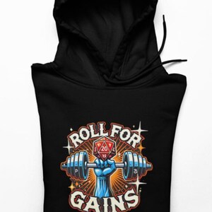 以下が含まれることがあります： 「Roll for Gains」と書かれたグラフィックが特徴の黒いパーカー。デザインは、赤い20面ダイスを中央に、バーベルを持つ青い手を描いています。テキストとグラフィックはヴィンテージスタイルです。