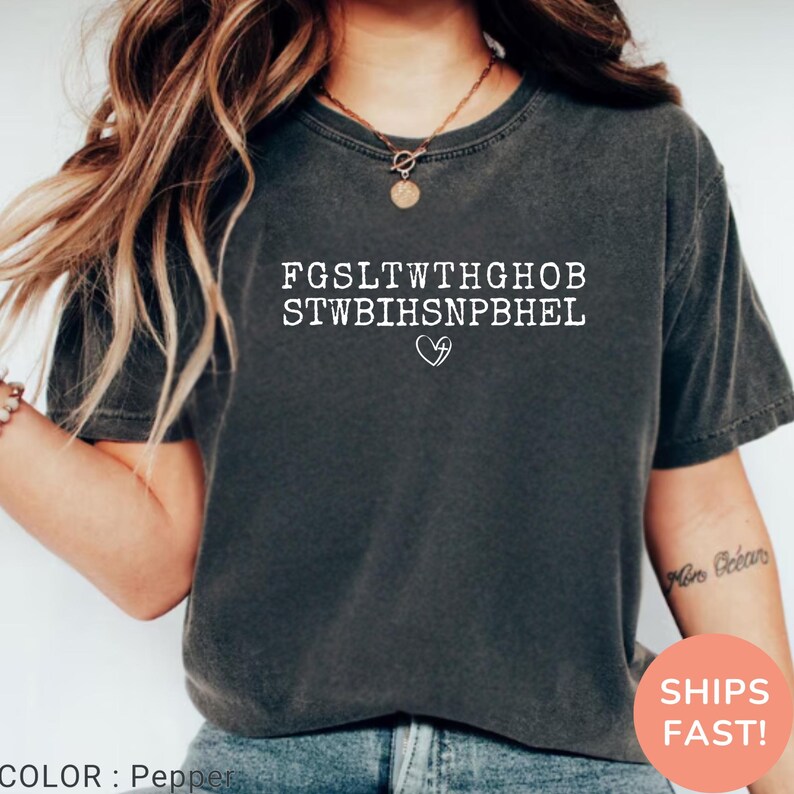 Pu&ograve; includere: T-shirt color pepe con testo bianco e simbolo a cuore. Il testo &egrave; una serie di lettere maiuscole disposte su due righe. La maglietta ha maniche corte e girocollo. Il colore &egrave; descritto come pepe.