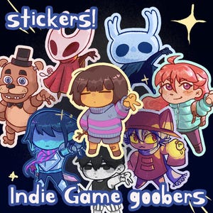 Könnte beinhalten: Eine Sammlung farbenfroher Aufkleber mit Charakteren aus verschiedenen Indie-Videospielen. Die Aufkleber zeigen Charaktere aus Hollow Knight, Undertale und Five Nights at Freddy's, mit dem Text "stickers!" und "Indie Game goobers".