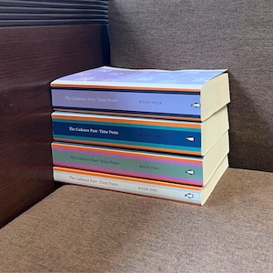 May include: A stack of four books titled "The Cadence Part-Time Poets" with colorful spines. Each book is labeled with a number: Book One, Book Two, Book Three, and Book Four. The books have a penguin logo.