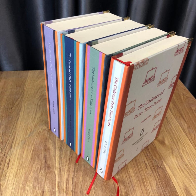 May include: A collection of hardcover books titled "The Cadence of Part-Time Poets." The books have colorful spines in shades of purple, blue, green, and orange. Each book has a red ribbon bookmark and gold corner protectors. The cover of the first book has a pattern of briefcases.
