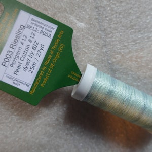 May include: A spool of light green pearl cotton thread with a label that reads "P003 Riesling Perlgarn #12 Pearl Cotton #12 dyed by BIZ 25m / 27yd Bestellnummer ordering code BP12-P003 Manufactured by House of Textile Arts Product of DE-Origin (EU)"