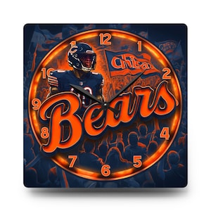 May include: Square wall clock featuring a Chicago Bears football player in a navy blue uniform. The clock face has an orange and navy blue design with the word "Bears" in large orange letters. The clock also has the word "Chicago" and a flag.