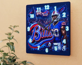 May include: A square wall clock featuring a Buffalo Bills football player in a blue uniform and helmet. The design includes the word Bills in large script, a crowd in the background, and glowing light blue numbers from 1 to 12 on a dark blue background.