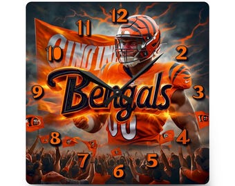 May include: A square wall clock featuring a Cincinnati Bengals football player in an orange jersey and helmet, with the team name Bengals in large black script, a crowd in the background, and orange numbers 1 through 12 on the clock face.