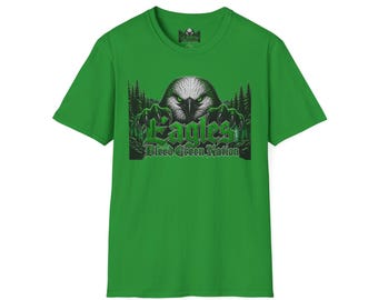 May include: A bright green short-sleeve t-shirt featuring a graphic of a white-headed eagle with sharp talons emerging from a dark forest. The text "Eagles" and "Bleed Green Nation" is printed in a bold, stylised green font below the eagle.