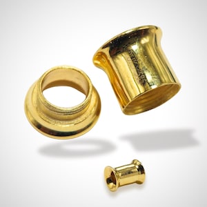 May include: Three gold-colored metal pieces, two are round with a raised lip and one is a short cylinder. The cylinder has the text "BRITA 205" engraved on the side.