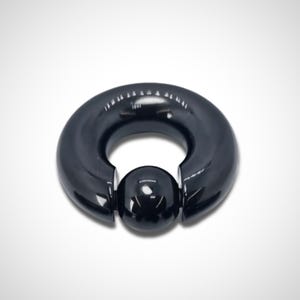 K&ouml;nnte beinhalten: Schwarzer runder Barbell mit einer schwarzen Kugel in der Mitte. Der Barbell ist aus Chirurgenstahl und hat einen Durchmesser von 12,7 mm.