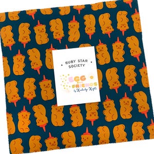 Puede incluir: Pieza de tela cuadrada con un patrón repetido de formas de ositos de goma naranjas sobre un fondo azul verdoso oscuro. Una etiqueta blanca en el centro dice "RUBY STAR SOCIETY" y "EGG & FRIENDS by Kimberly Knight."