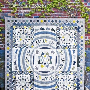 Könnte beinhalten: Ein Quilt mit einem geometrischen Muster in Blau, Weiß und Gelb. Der Quilt trägt den Titel "Burrows + Boughs" von Jen Kingwell.
