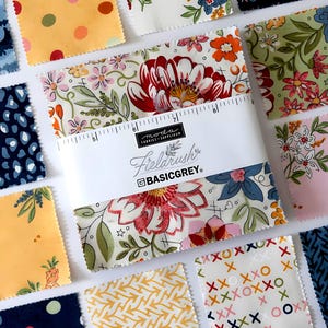 Puede incluir: Una colección de cuadrados de tela con varios patrones florales y geométricos. Los cuadrados son en tonos de amarillo, rosa, azul y verde. Un paquete de cuadrados de tela está envuelto con una banda blanca que dice "Fieldrush" y "BASICGREY."