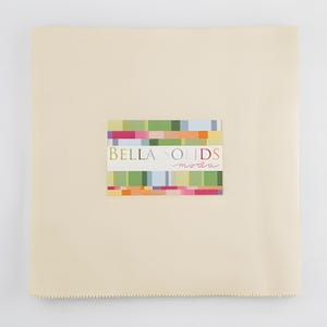 May include: A cream-colored fabric square with a colorful rectangular label in the center. The label features the text "BELLA SOLIDS moda" in a mix of colors. The fabric has a textured appearance and a stitched edge.