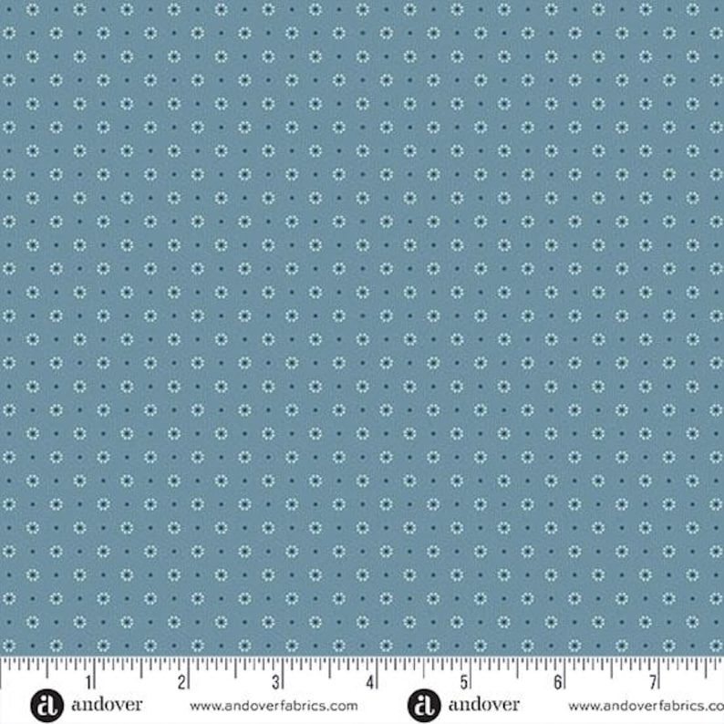 May include: Blue fabric with a repeating pattern of small white and dark blue floral designs. The fabric has a ruler along the bottom edge with the Andover Fabrics logo.