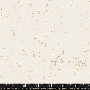 May include: White fabric with a scattered gold and white speckled pattern. The fabric is marked with a ruler and the text "RUBY STAR SOCIETY".