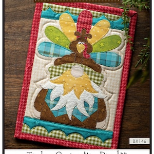May include: A colorful Turkey Gnome Mug Rug kit with instructions, precut fused appliqué, and all the fabric needed to complete the mug rug. The finished size is 7 inches by 10 inches. The kit is from The Whole Country Caboodle and is labeled BX146.