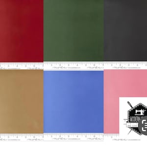 May include: A selection of solid-coloured fabric swatches in red, green, black, gold, blue, and pink. Each swatch is square, and a ruler is visible along the bottom edge. The Modern Sew Like logo is in the bottom right corner.