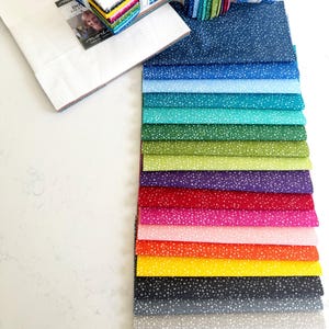 Pode incluir: Uma coleção de 18 amostras de tecido com um padrão de bolinhas brancas sobre uma variedade de fundos coloridos, incluindo azul marinho, azul claro, turquesa, verde, verde oliva, roxo, vermelho, rosa, laranja, amarelo, cinza e bege.