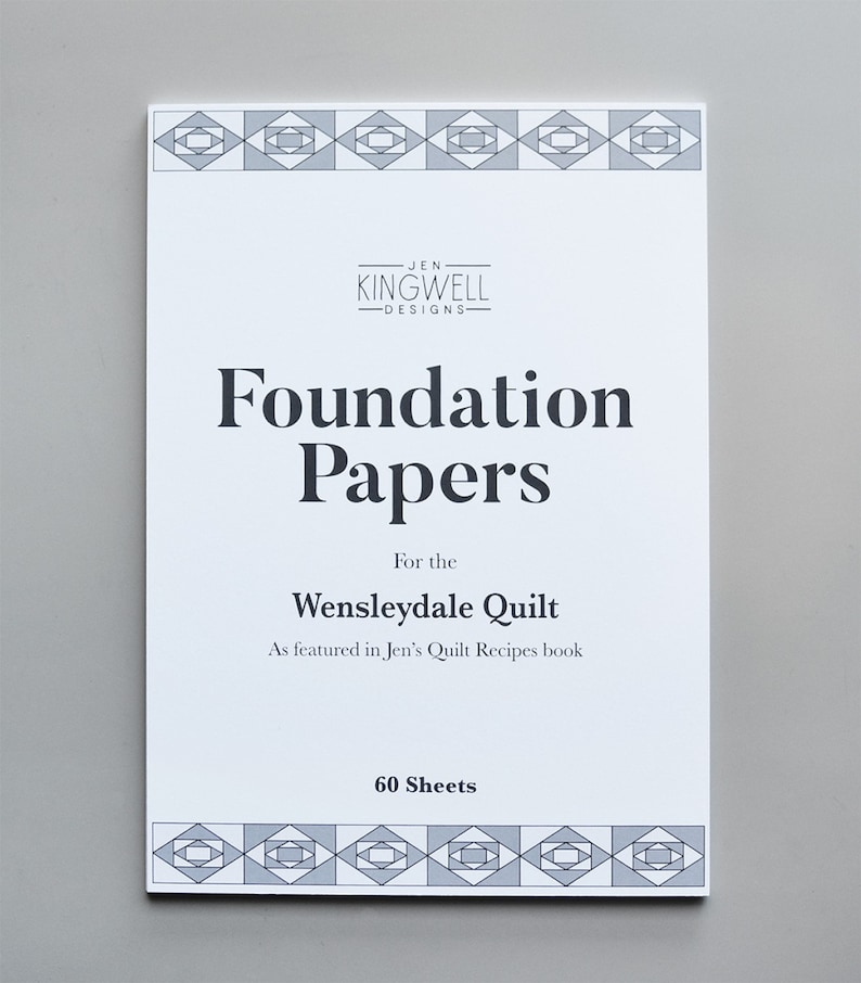 May include: A white booklet with a black and gray geometric pattern on the front and back covers. The title "Foundation Papers" is printed in black, along with the text "For the Wensleydale Quilt" and "As featured in Jen's Quilt Recipes book". The bottom of the cover reads "60 Sheets".