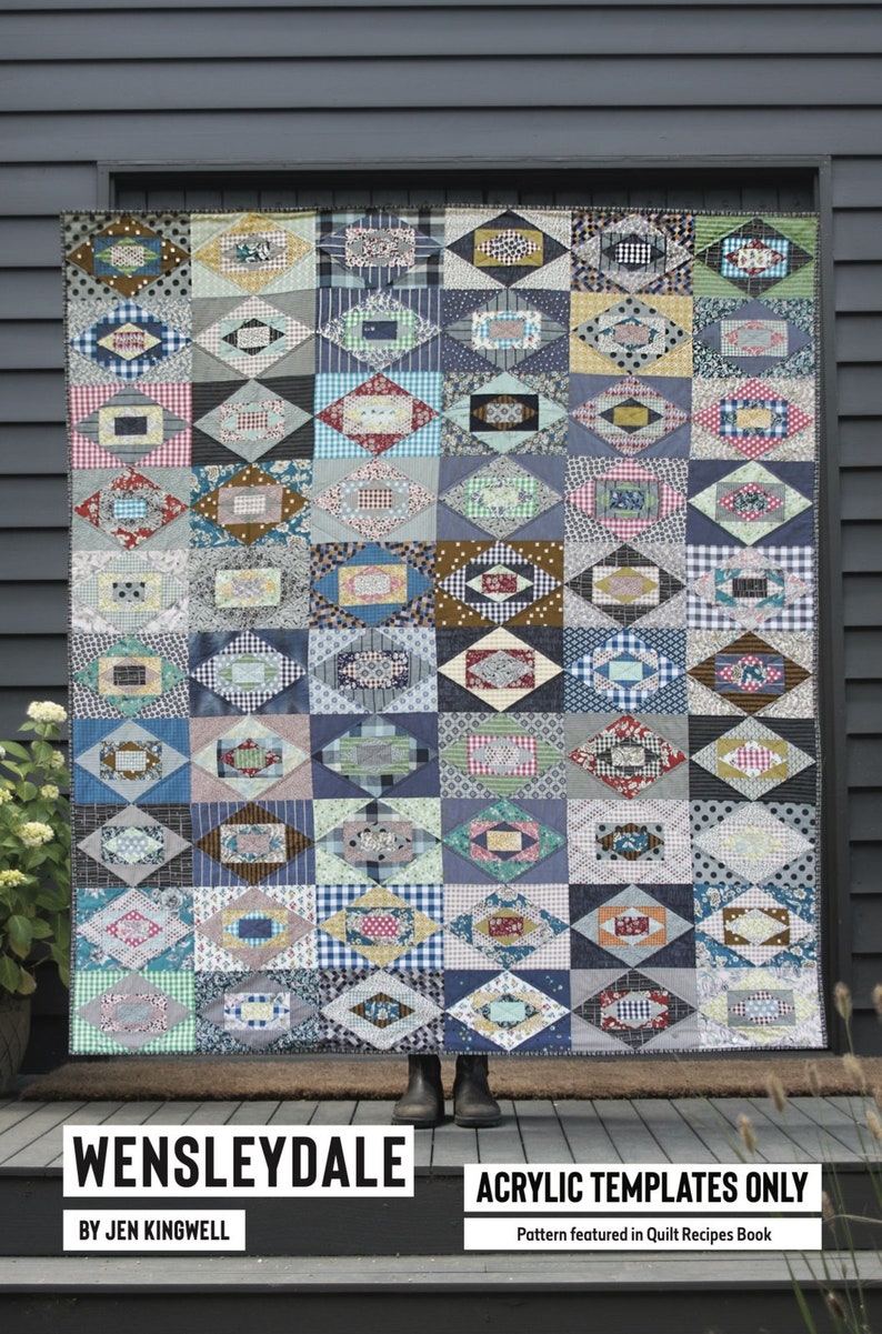 May include: A quilt pattern called "Wensleydale" by Jen Kingwell, featuring a geometric design with a variety of colorful fabrics. The quilt is displayed in front of a gray wooden door. The text "Acrylic Templates Only" and "Pattern featured in Quilt Recipes Book" is also visible.