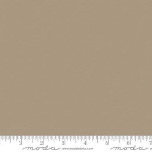 May include: A solid piece of fabric in a light brown color. The fabric has a subtle texture and is perfect for quilting, sewing, and crafting.