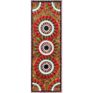 May include: A red, green, and white table runner with a geometric pattern of concentric circles. The circles have a black center and white spokes radiating outward.