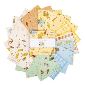 Può includere: Una collezione di quadrati di tessuto di Winnie the Pooh in vari colori, tra cui giallo, blu e beige. Il tessuto presenta illustrazioni di Pooh, Pimpi e altri personaggi, insieme a citazioni e disegni di mappe. I quadrati sono disposti in un motivo circolare.