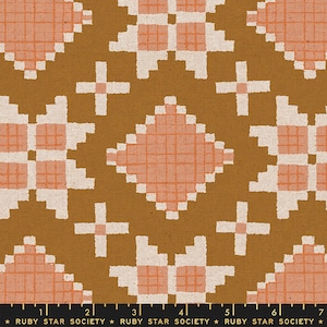 May include: A brown fabric with a repeating pattern of pink and white geometric shapes. The pattern is a combination of squares, diamonds, and crosses. The fabric is textured and has a slightly rough feel.