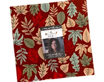 May include: A square fabric piece with a burgundy background and a repeating pattern of autumn leaves in shades of green, beige, and red. A small tag with a woman's photo and the text "moda FABRICS + SUPPLIES" is attached.