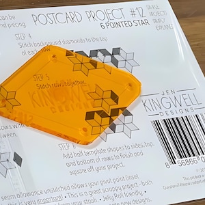May include: An orange, clear plastic quilting template with a six-pointed star design, labeled "Postcard Project #12" and "Jen Kingwell Designs." The template is placed on a white paper with instructions and diagrams for quilting.