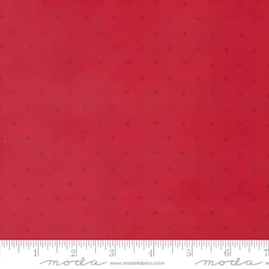 May include: Red fabric with a subtle texture and small, evenly spaced dark dots. The fabric has a solid red background with a slight sheen. A ruler is at the bottom of the image.