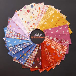 May include: A circular arrangement of colorful fabric squares with various patterns, including balloons, geometric shapes, and floral designs. The fabrics are in shades of blue, pink, yellow, and orange. The center features the text "PERSIMMON RASHIDA COLEMAN-HALE".