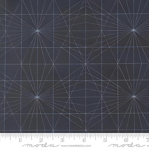 May include: Dark blue fabric with a geometric pattern of radiating lines and grid squares. The design features a series of starburst-like shapes connected by straight lines, creating a modern, abstract design. The fabric has a ruler along the bottom edge.
