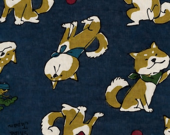 May include: A navy blue fabric featuring a repeating pattern of Shiba Inu dogs in various poses. The dogs are depicted in shades of brown, white, and tan, wearing bandanas in red, green, and blue. The words "Shiba Japan" are printed on the fabric.