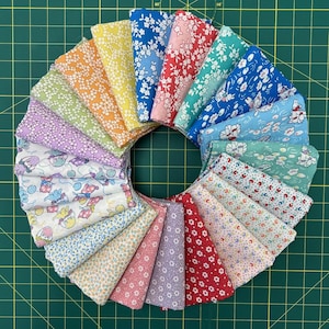 May include: A collection of 20 fabric squares in various floral patterns, arranged in a circle on a green cutting mat. The fabrics feature a variety of colors, including pink, blue, green, yellow, and white.