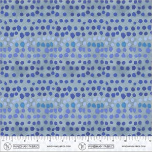 May include: A fabric with a repeating pattern of blue and purple dots on a light blue background. The dots vary in size and shade, creating a textured appearance. The fabric has a subtle, mottled effect.