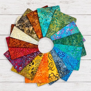 May include: A circular arrangement of fabric swatches featuring a variety of batik patterns in a spectrum of colors including red, orange, yellow, green, blue, purple, and brown, each displaying distinct floral and leaf motifs on cotton material.