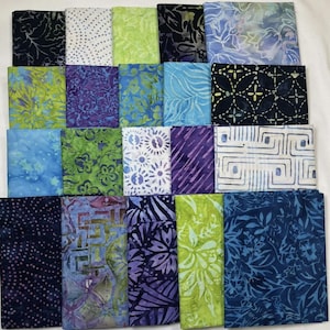 May include: A collection of 18 fabric squares in various shades of blue, green, and purple with different patterns, including floral, geometric, and abstract designs.