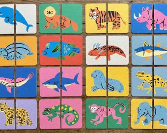 May include: A set of sixteen square animal puzzle cards. Each card is split into two halves, featuring colorful illustrations of various animals like a dolphin, tiger, and elephant. The cards are arranged in a grid pattern.