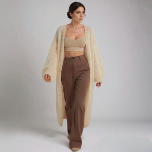An elegant beige cardigan, showcasing its knitted texture.