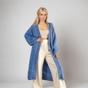 A woman in a casual yet stylish outfit featuring a jeans-blue cardigan.