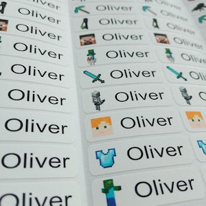 May include: A sheet of rectangular white adhesive labels featuring the name Oliver printed in black sans-serif font. Each label includes a small, colourful pixelated graphic inspired by Minecraft, such as swords, pickaxes, and various game characters.