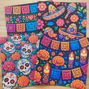 May include: Four square cards featuring vibrant Day of the Dead motifs. Designs include colorful sugar skulls, marigold flowers, papel picado banners, sombreros, maracas, and lit candles against deep black and bright blue backgrounds.