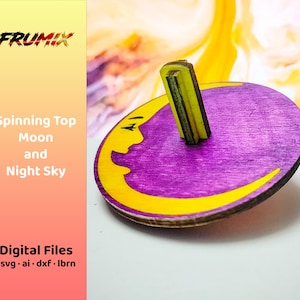 Puede incluir: Una peonza de madera con base morada y diseño de media luna amarilla. La peonza tiene un mango amarillo y verde. El texto "Spinning Top Moon and Night Sky" es visible en el lado izquierdo de la imagen.