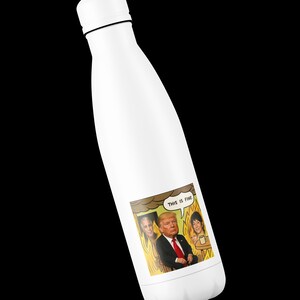 May include: White insulated water bottle with a black cap and a cartoon sticker. The sticker features a cartoon of a man in a suit with the text "THIS IS FINE" in a speech bubble. The cartoon shows the man with two other people in a burning room.